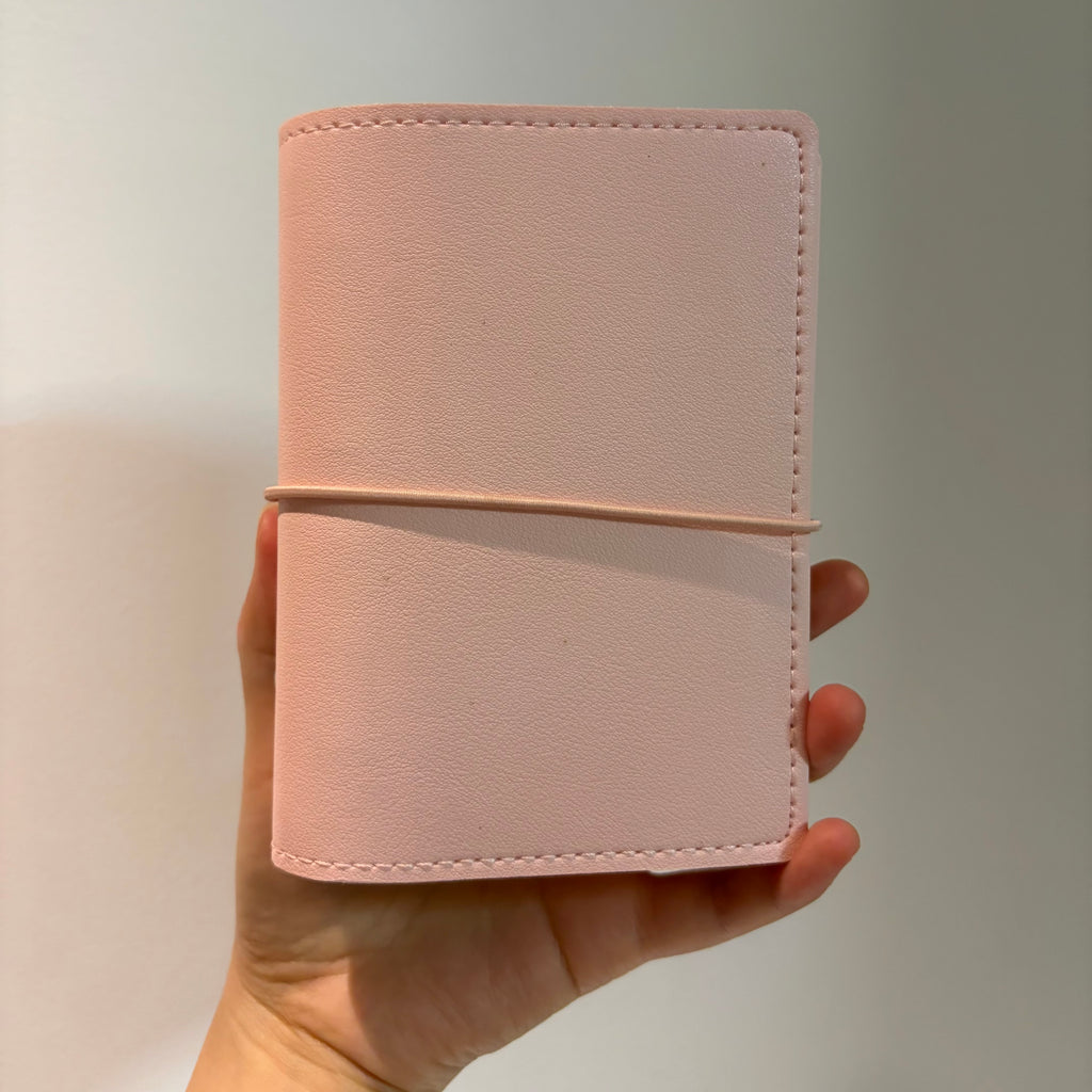 Woman holding an aesthetic A7 soft blush pink binder cover in her hand