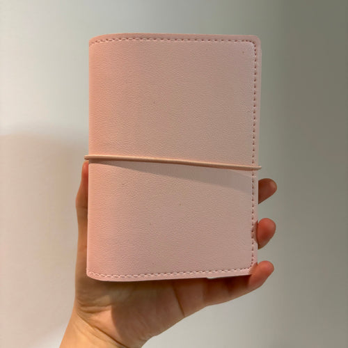 Woman holding an aesthetic A7 soft blush pink binder cover in her hand