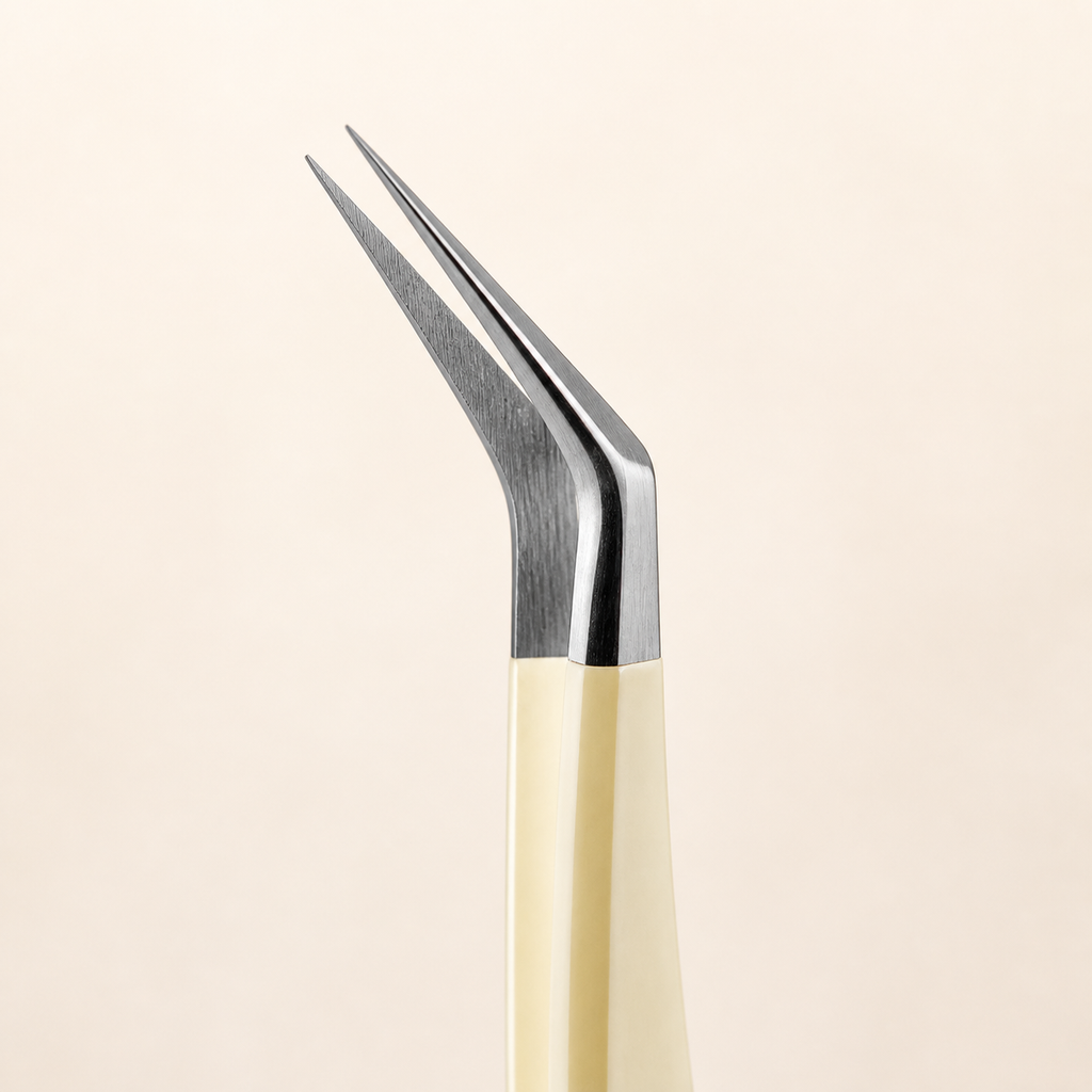 Close-up detail of the aligned silver angled tip on cream sticker tweezers