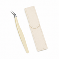 Cream angled-tip sticker tweezers with silver tip and individual ivory protective case