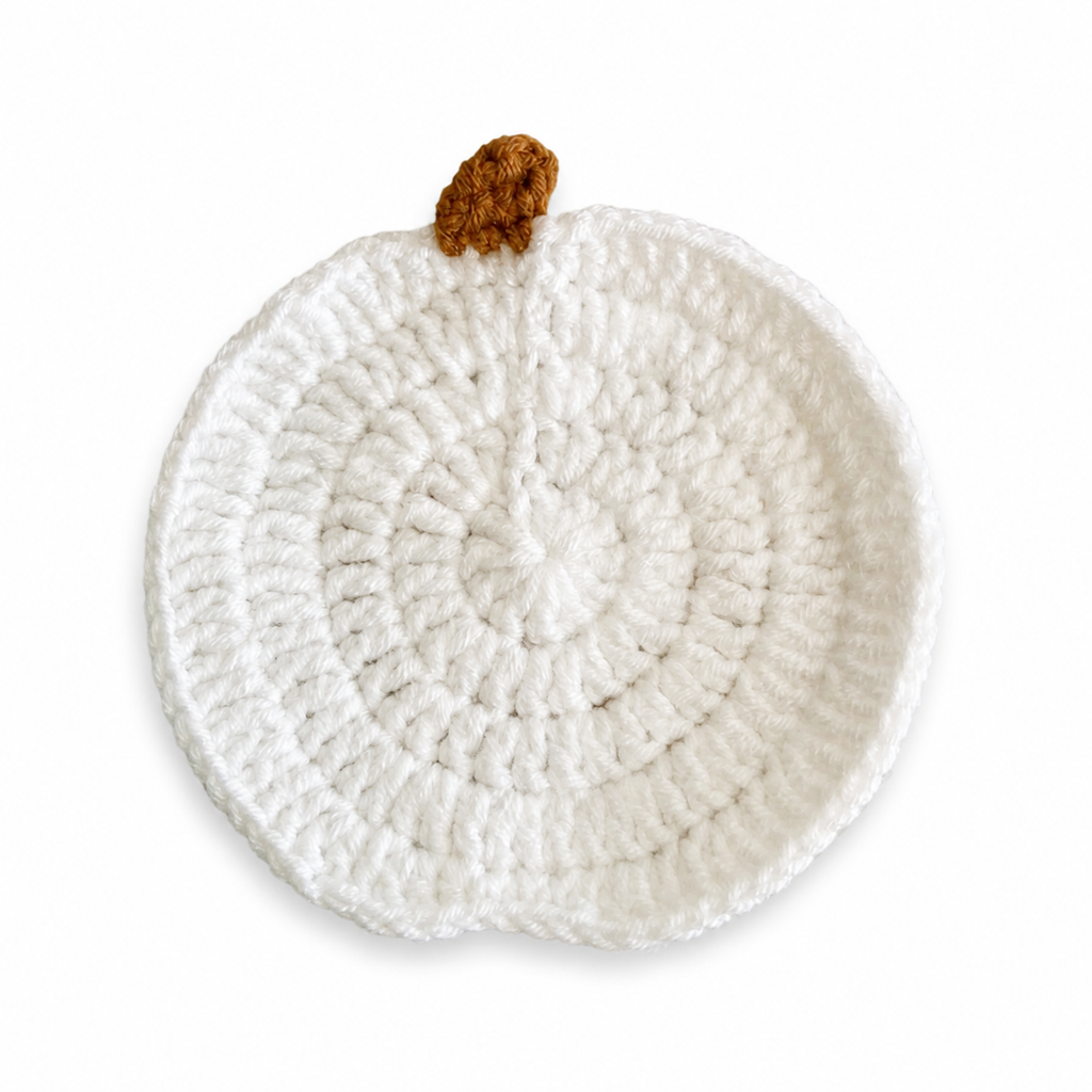 White crochet pumpkin coaster on a pure white background