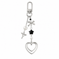 Dark double heart keychain charm with black star bead and silver bow on a white background