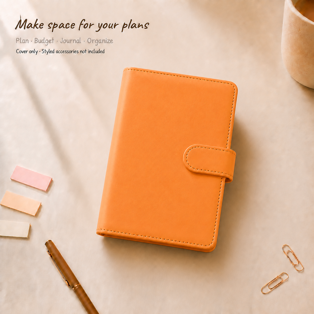 Orange A6 Macaron six-ring planner binder cover on a warm ivory desk; styled accessories are not included
