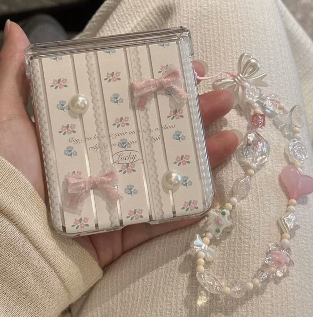 Pink heart beaded charm strap styled with a clear planner cover and soft floral details