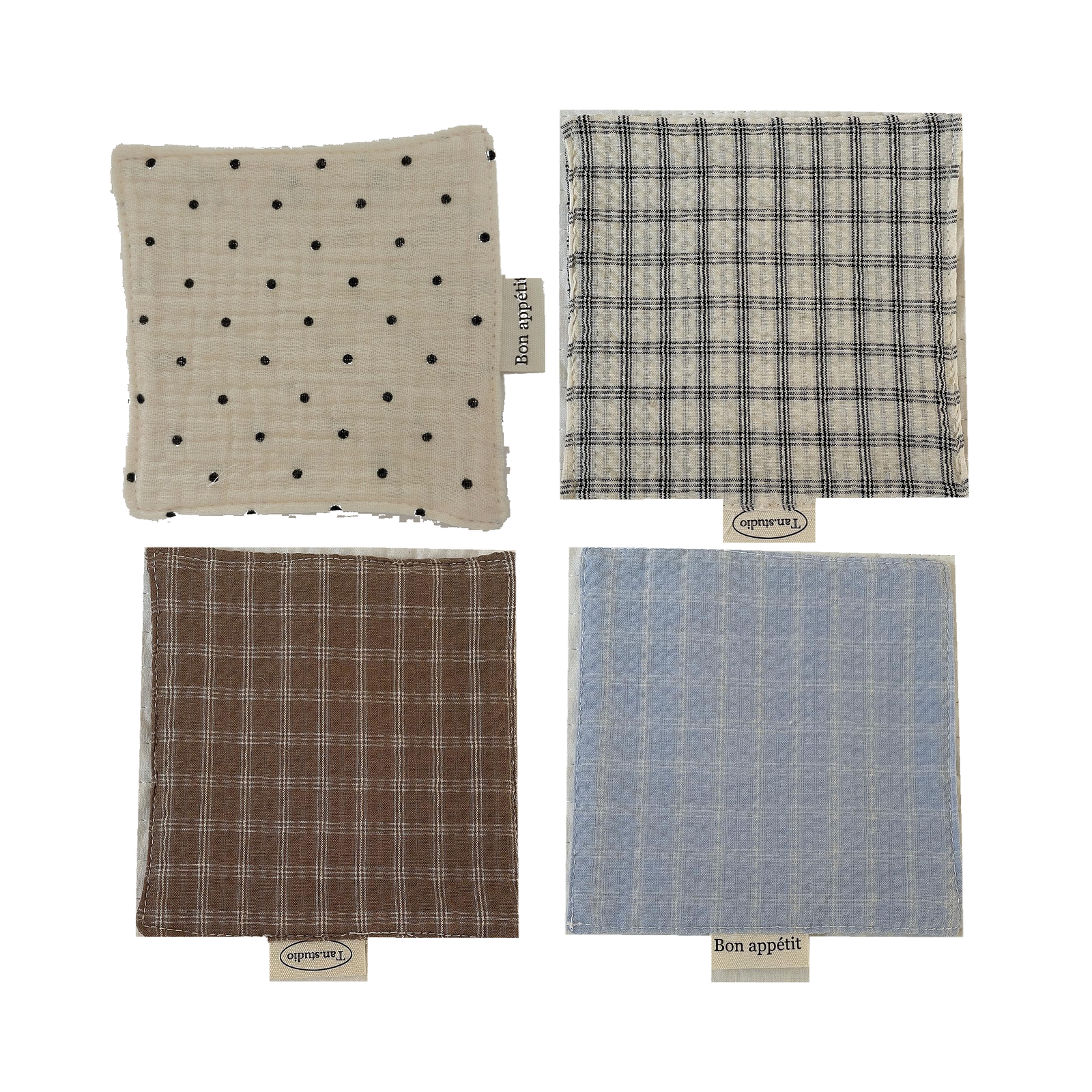 Set of four soft gauze fabric coasters in dot, black white grid, brown grid, and blue grid patterns