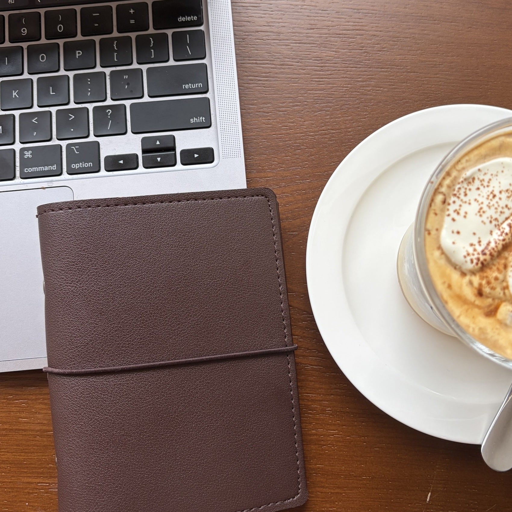 Cocoa brown A7 pocket planner cover styled on a cafe desk with coffee