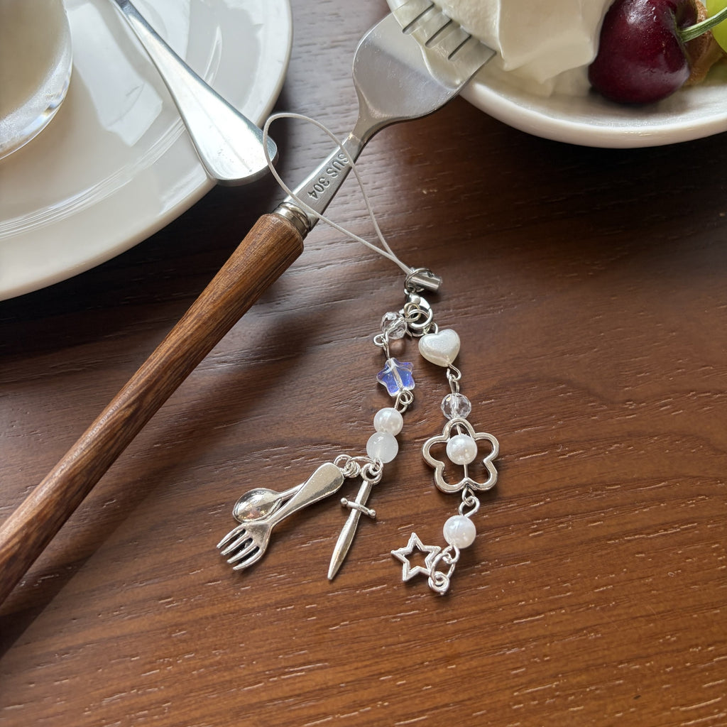 Fork spoon knife phone charm styled on a dessert table