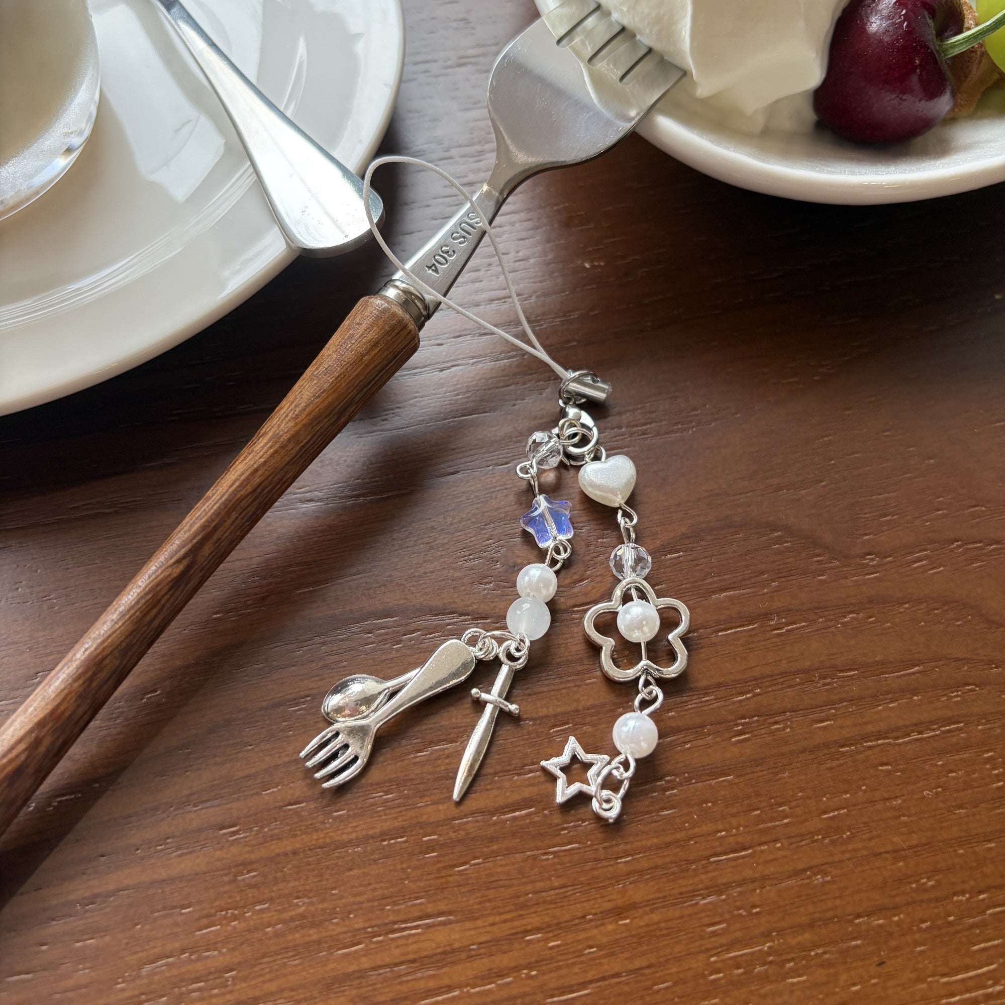 Fork spoon knife phone charm styled on a dessert table