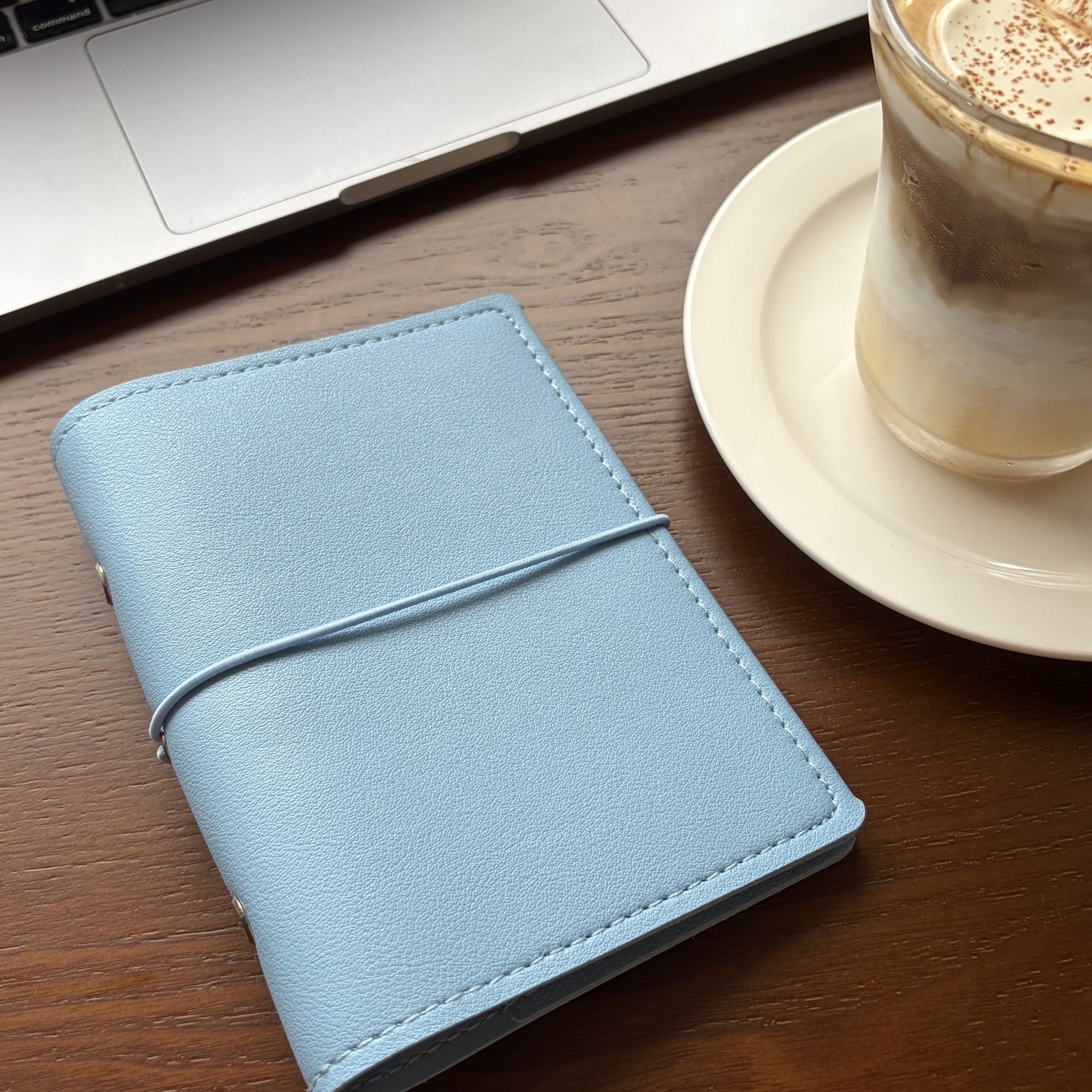 Ocean blue A7 pocket planner cover styled on a cafe table with iced coffee