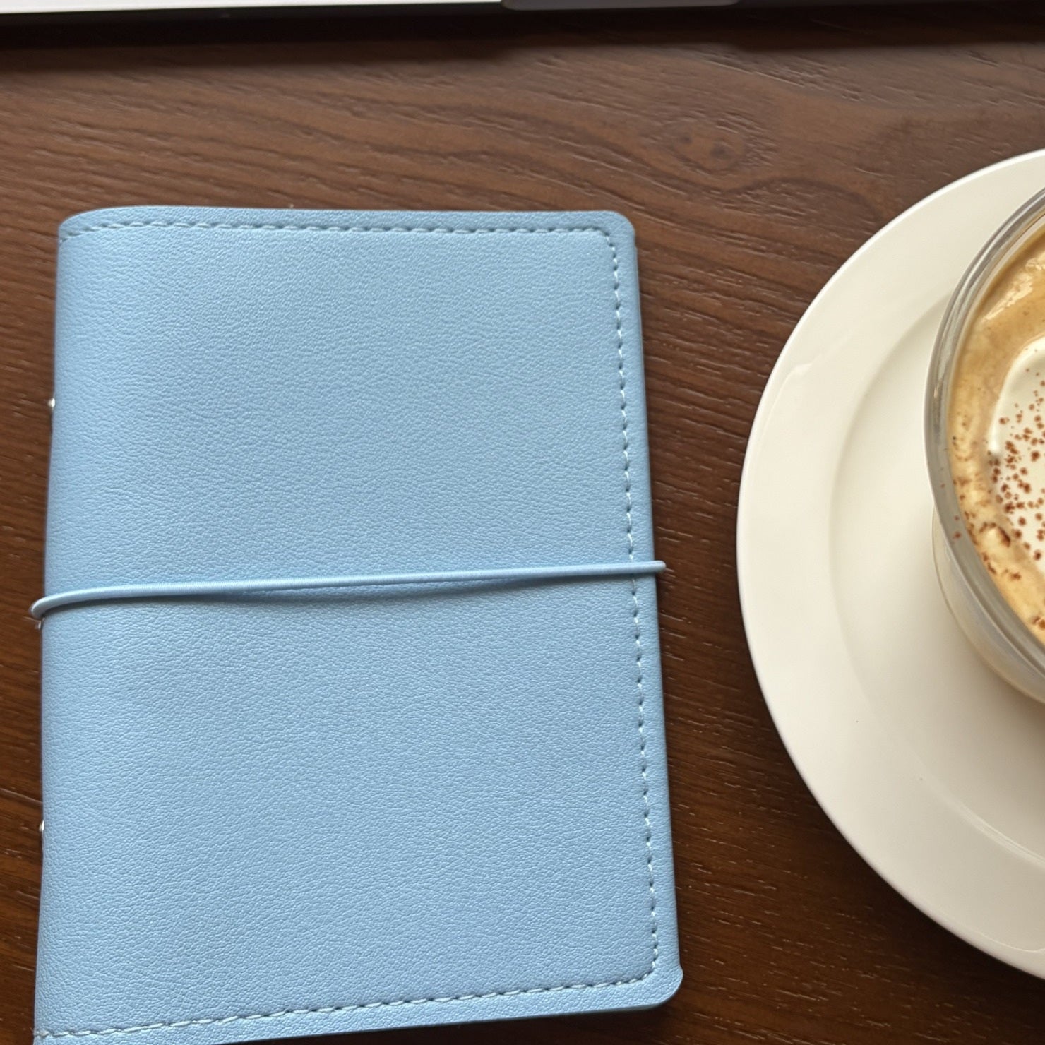 Ocean blue A7 pocket planner cover in a desk setup with coffee