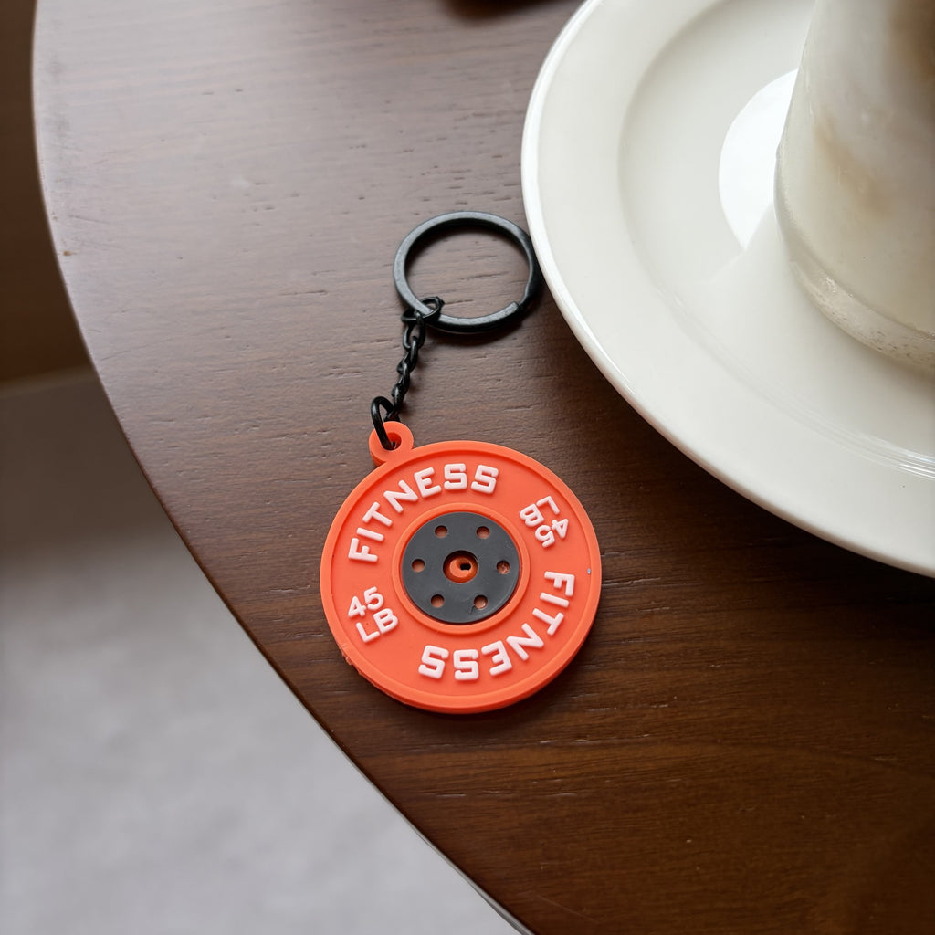 Orange weight plate planner charm styled on a cafe table