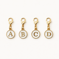 White and gold clip-on initial planner charms showing letters A, B, C, and D on a white background